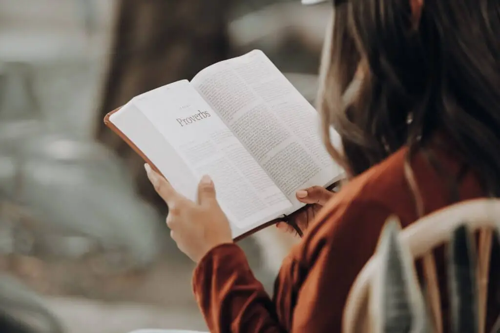 Woman holding a bible open to Proverbs